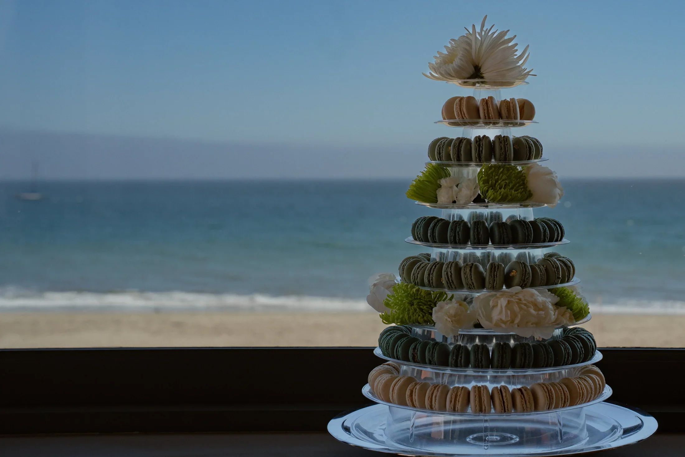 Reve Patisserie macarons tower against the ocean backdrop