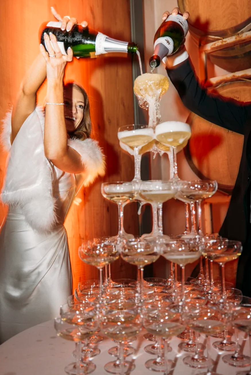 Couple pouring champagne into champagne tower