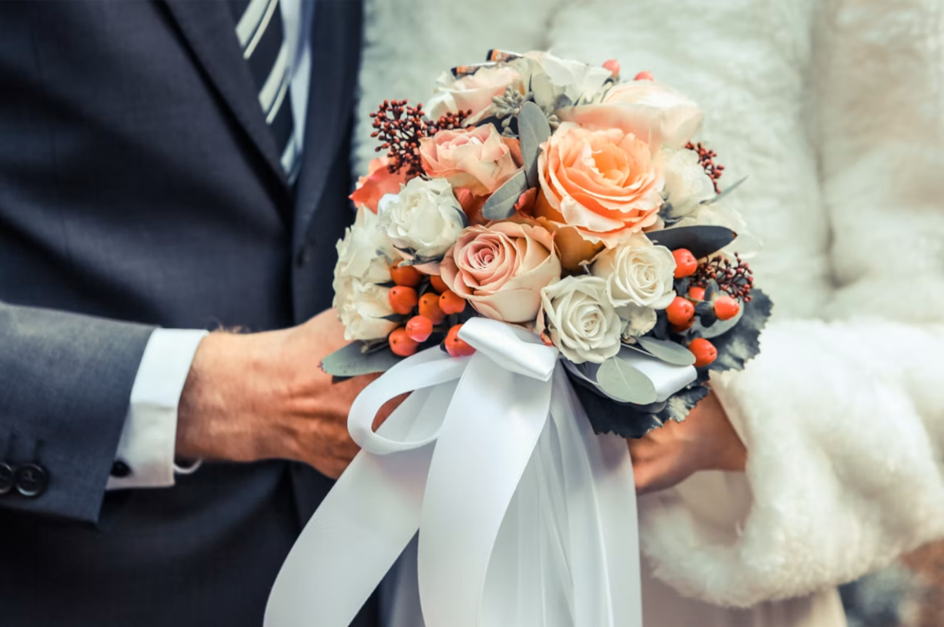 Bride and groom holding fall bouquet