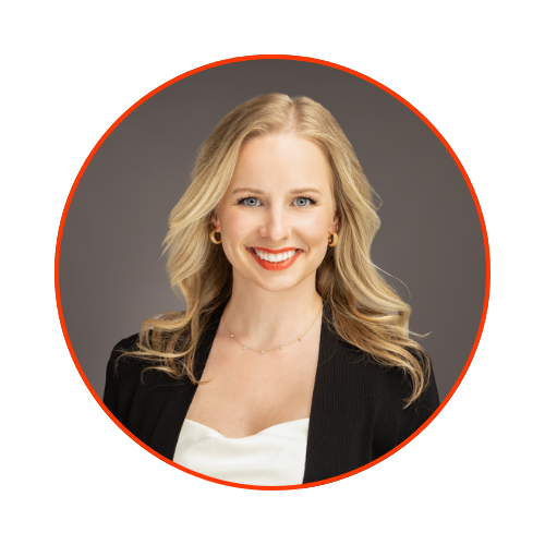 Headshot of a smiling blonde woman with wavy hair, wearing a black blazer over a white top, against a gray background.