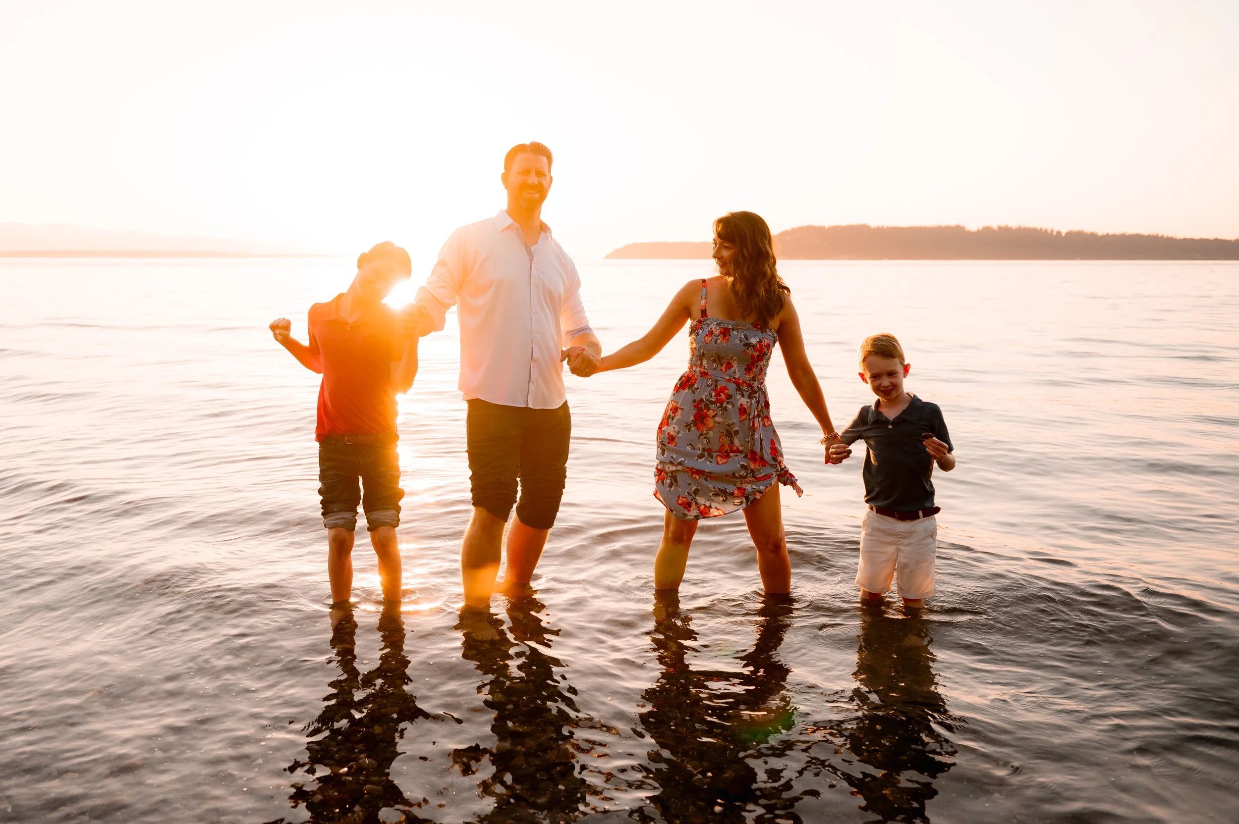 Sunset family photos in Seattle and family is dancing in the water