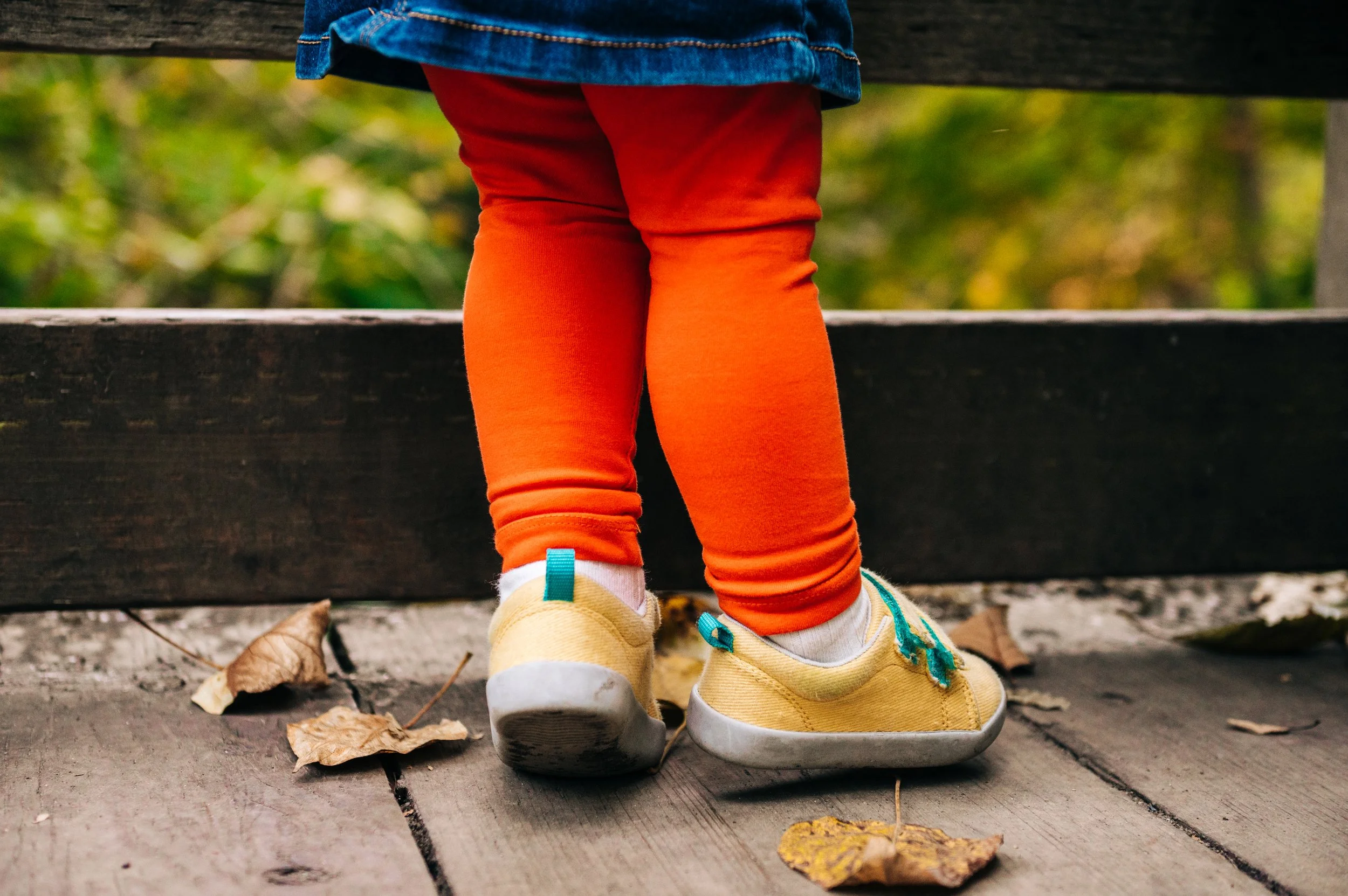 bright orange leggings and yellow shoes in a detail shot at a family photography session at a Kenmore Park.