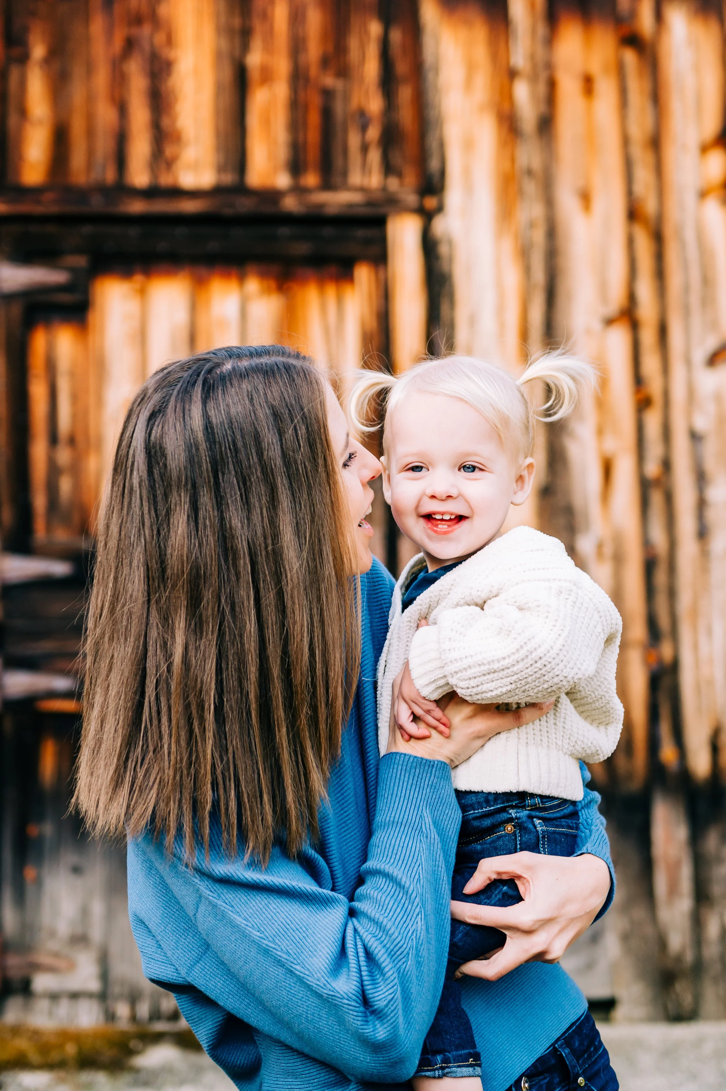 Kirkland family photography session with mom holding adorable little blonde daughter with pigtails.