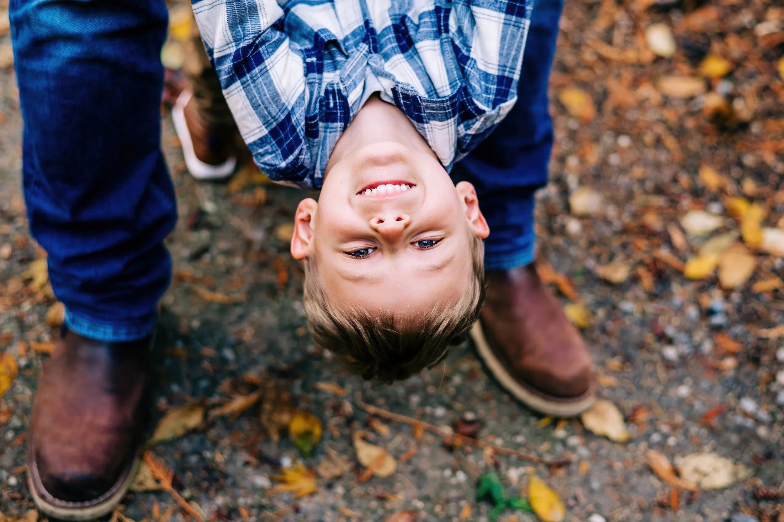 Boy playing with dad and being turned upside down during family photos at the UW Arboretum in Seattle