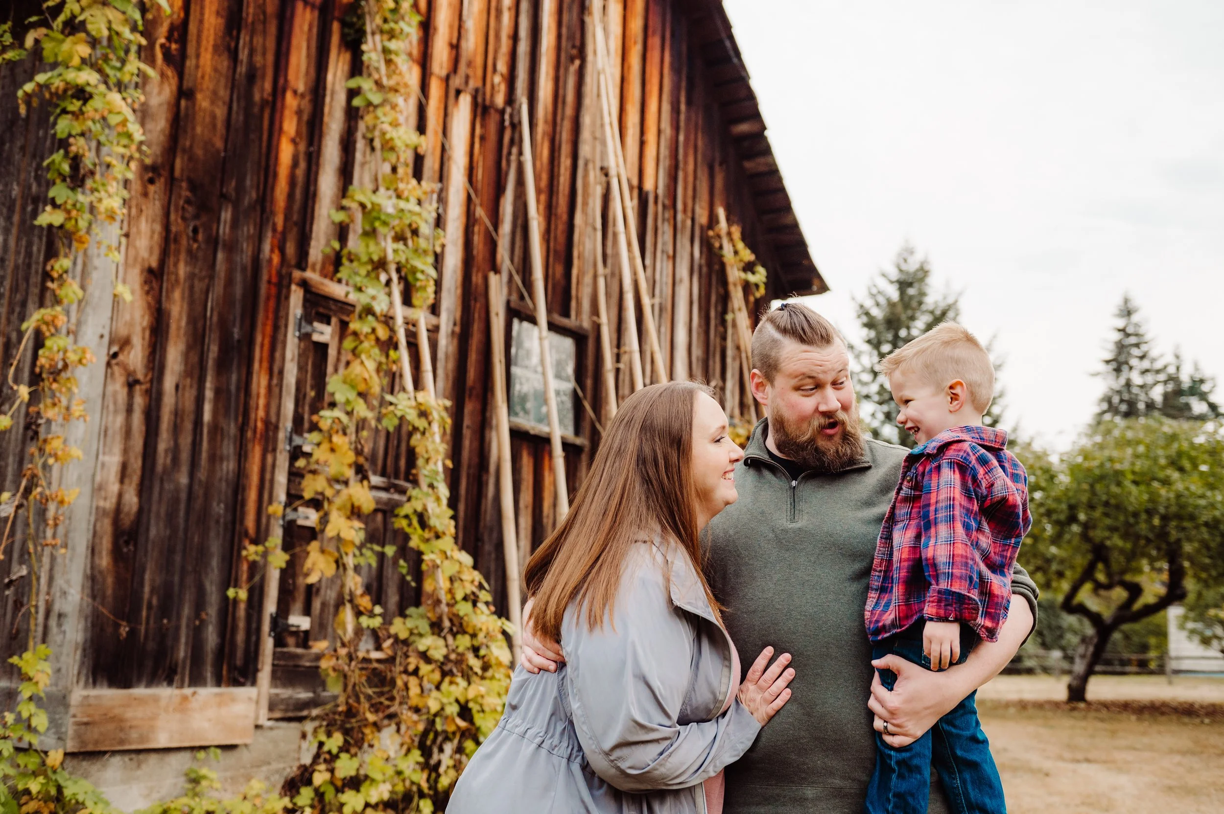 Family photos with son in dad's arms at a park in Kirkland