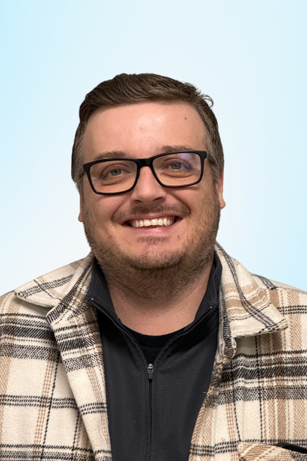 image of Jason Bacon, a white man, wearing glasses. Short, tidy dark hair, wearing a black shirt with a beige and brown plaid jacket