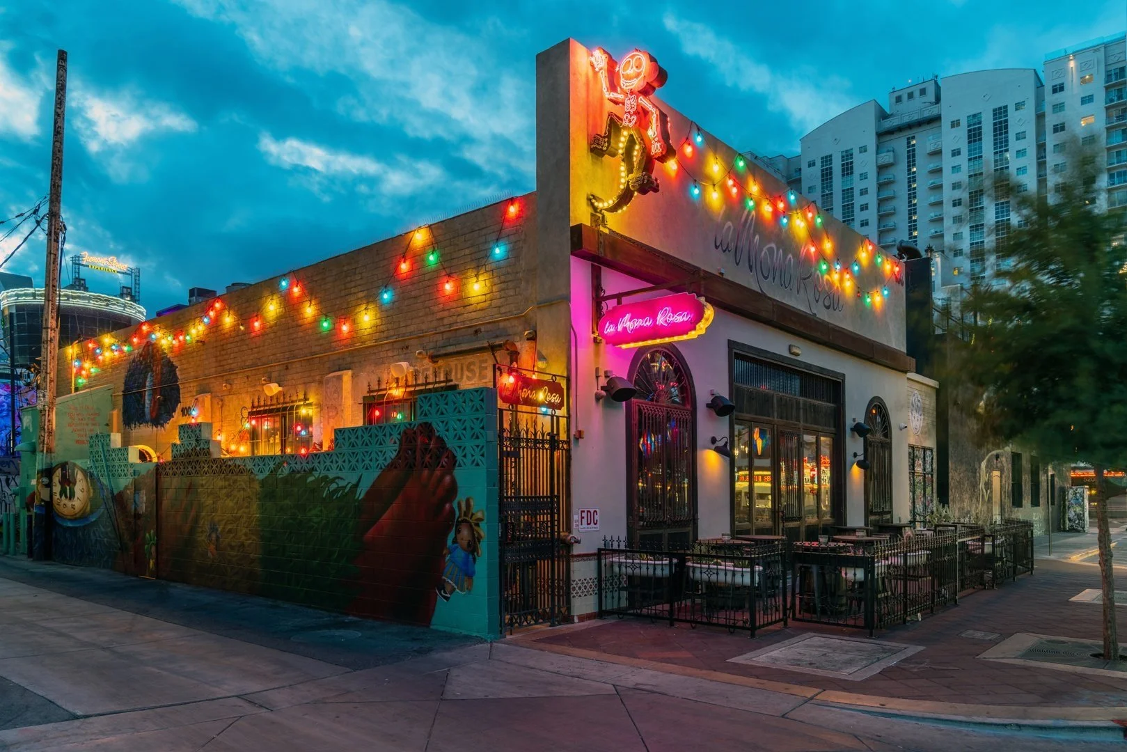 Colorful restaurant exterior with string lights and mural art.