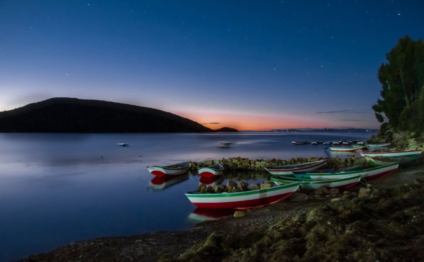 sunset and boats on lake titicaca, bolivia, an Underrated country to visit