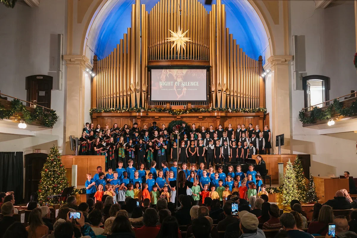 Children's and youth choirs from Edmonton after-school programs perform under a pipe organ at a holiday concert