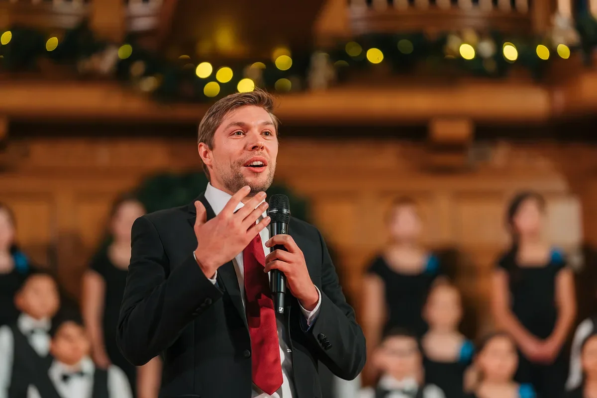 Christian Maxfield, director of Spiritus boys choir in Edmonton, speaking to the audience at a holiday concert