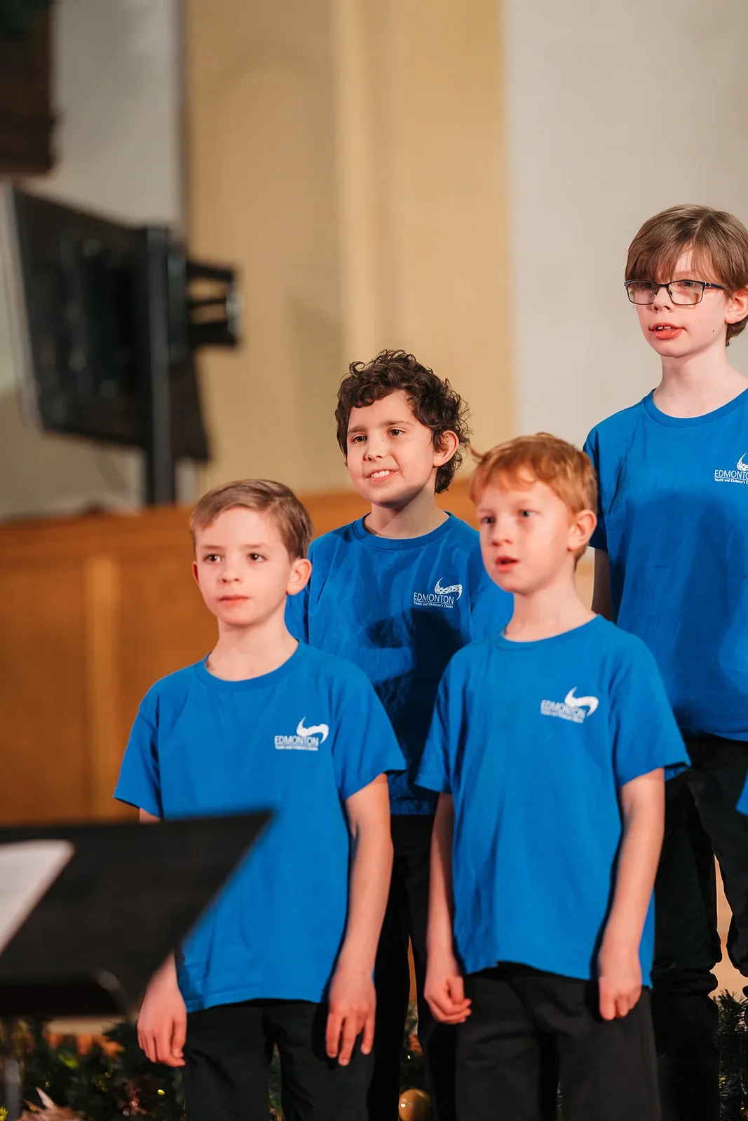 Young boys in blue Edmonton Youth and Children's Choirs shirts singing together