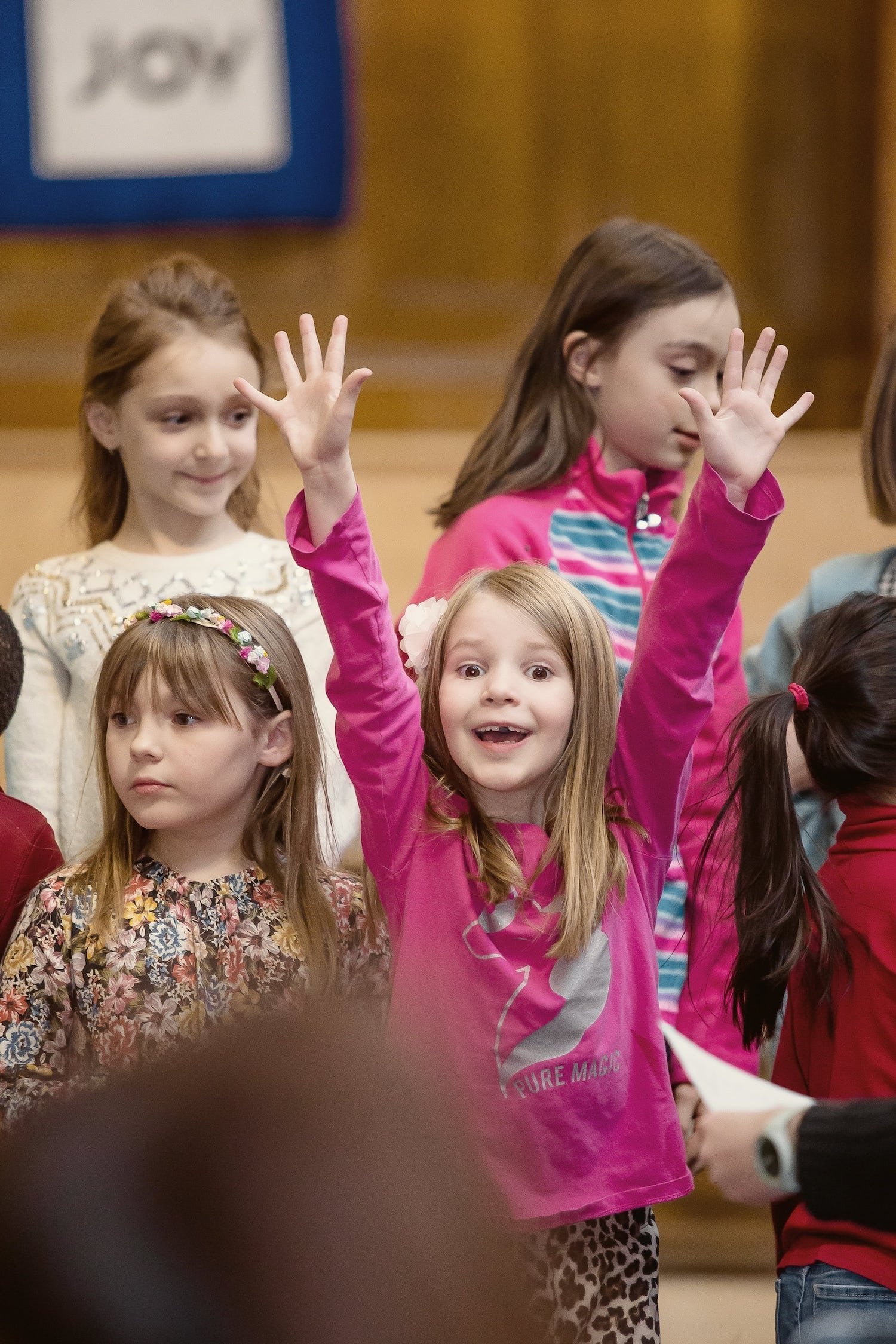 An excited singer raising her hands from ready set sing our edmonton summer music camps for kids