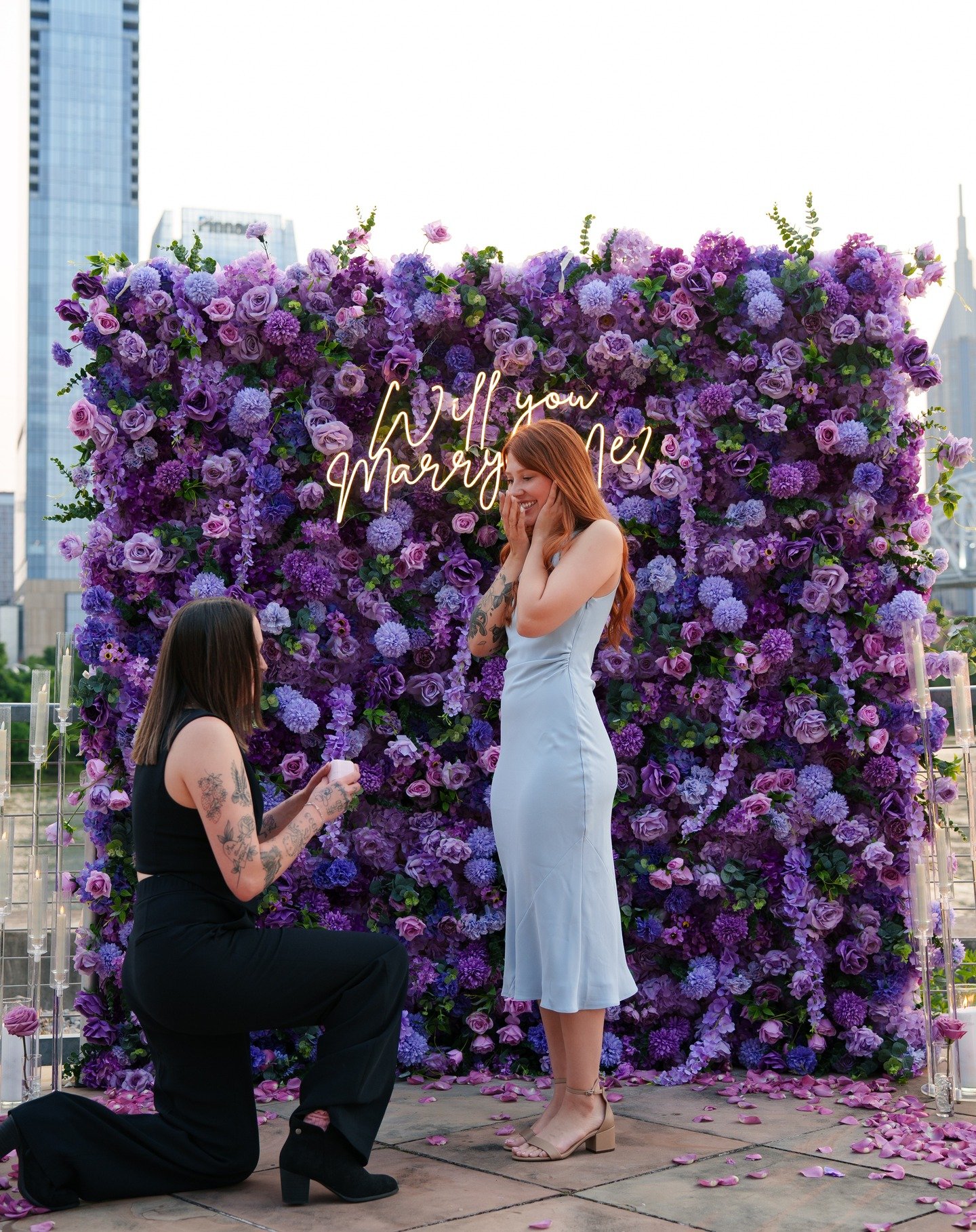 It was an absolute pleasure helping Hannah plan this unforgettable surprise proposal for her now fianc&eacute;. We designed a romantic, purple-themed setup featuring our Violet flower wall and scattered lavender rose petals to bring her vision to lif