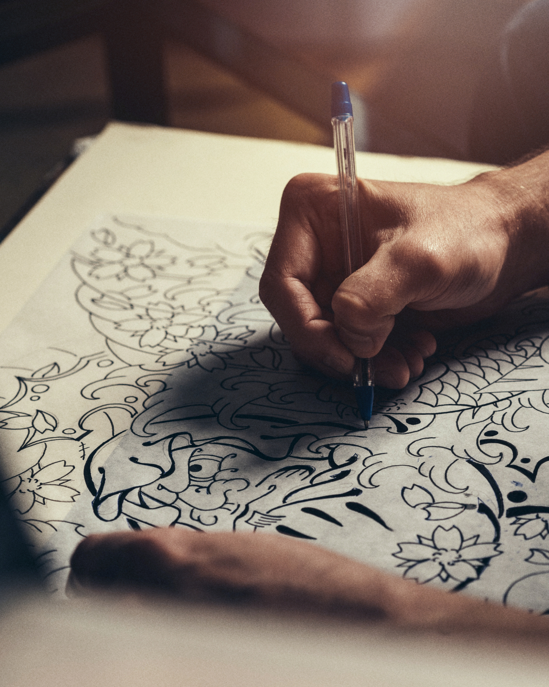 Aspiring tattoo artist sketching tattoo design ideas as part of apprenticeship preparation.