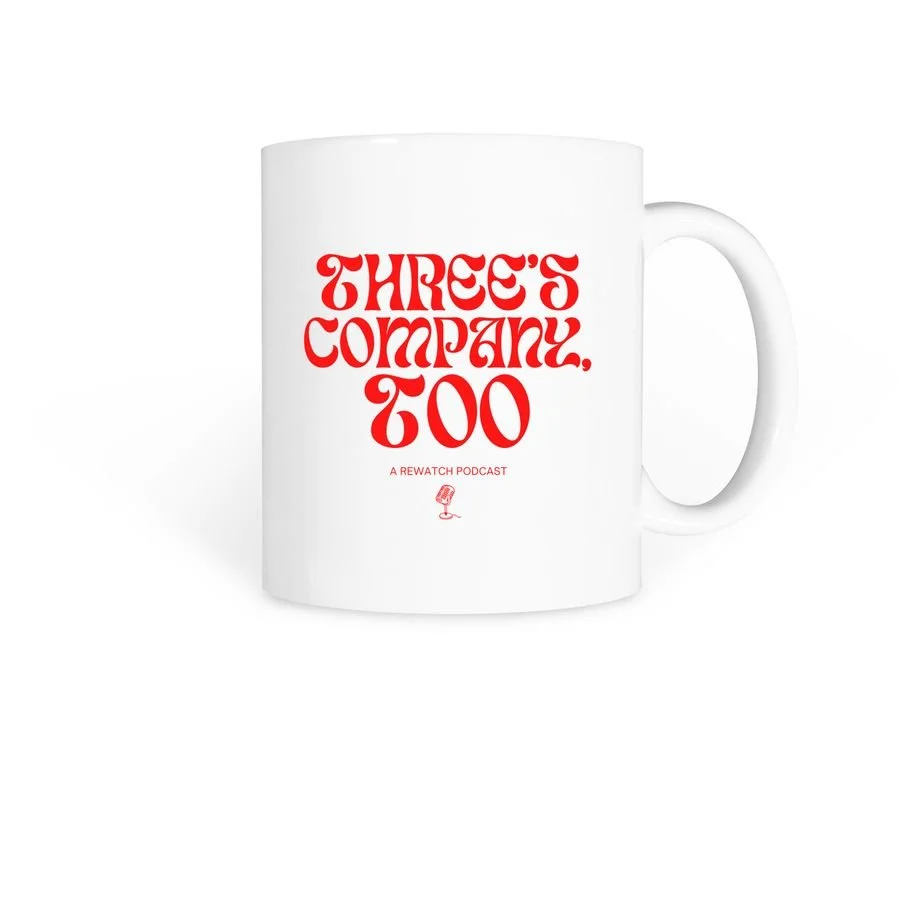 White coffee mug with red text that reads 'Three's Company, Too' and smaller text below saying 'A Rewatch Podcast' with a small microphone graphic.