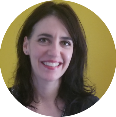 A smiling person infront of a yellow background 