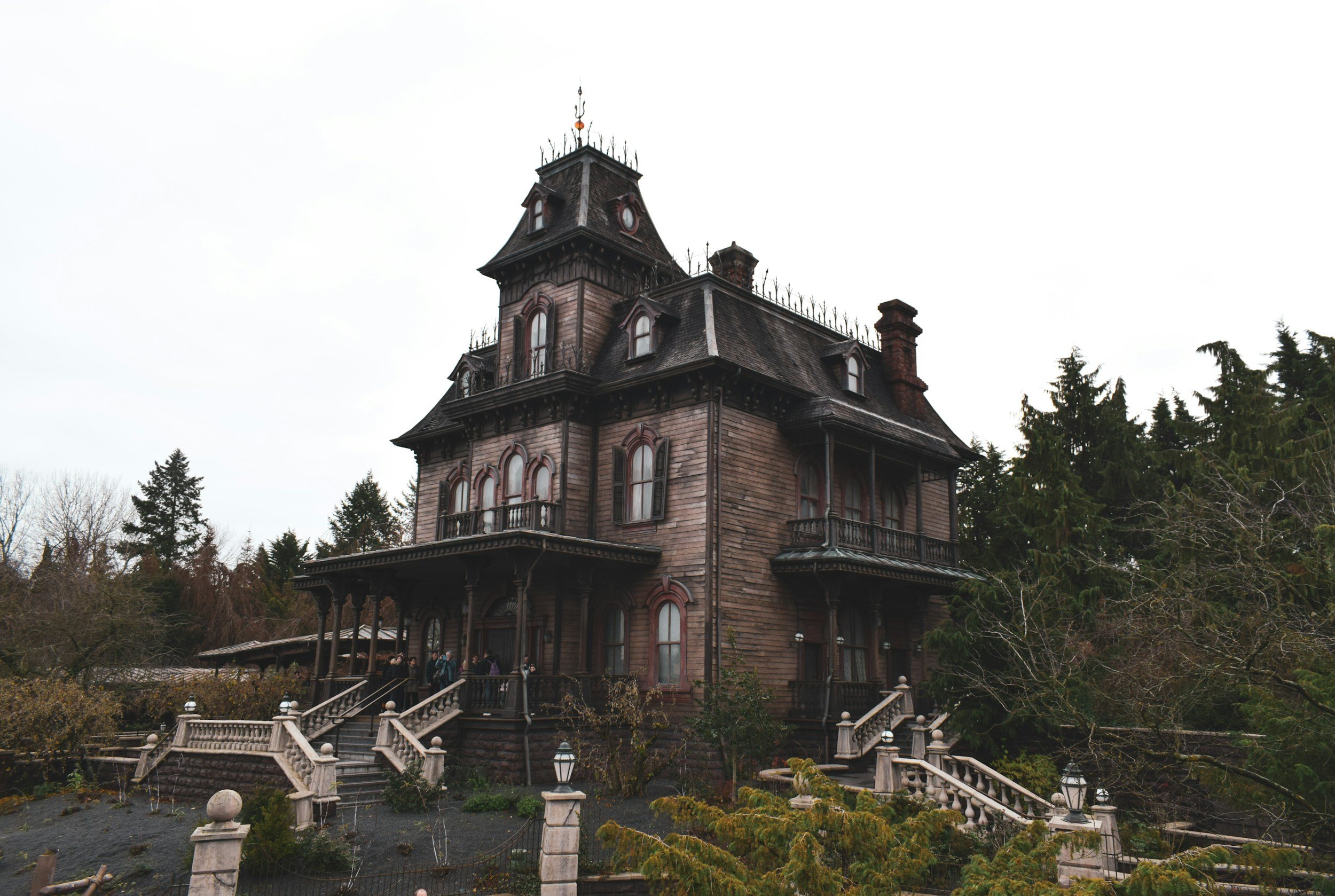 An imposing, dark Victorian gothic mansion under a bleak sky, serving as a cinematic brand photography example for horror authors