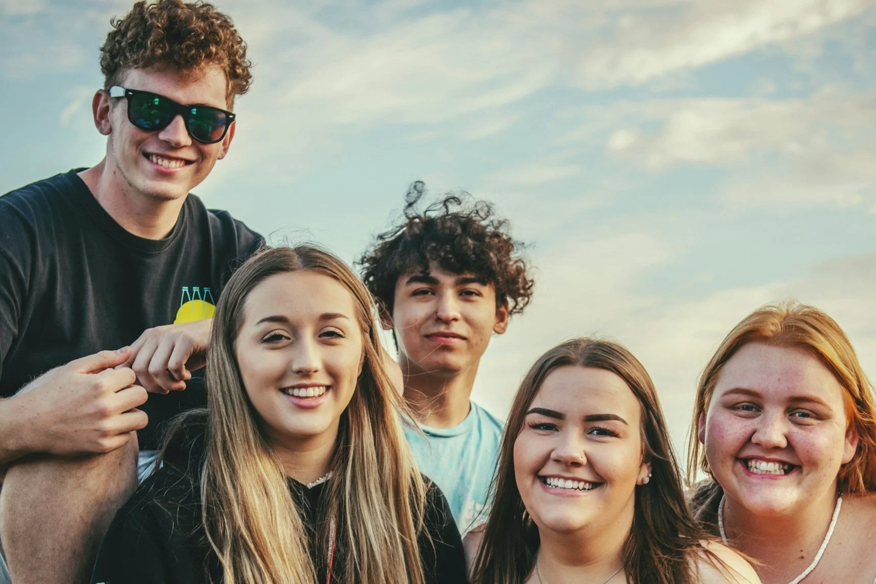 A group of smiling teenagers representing the supportive teen counseling services provided by Rachelle at Everthrive Counseling in New Port Richey.