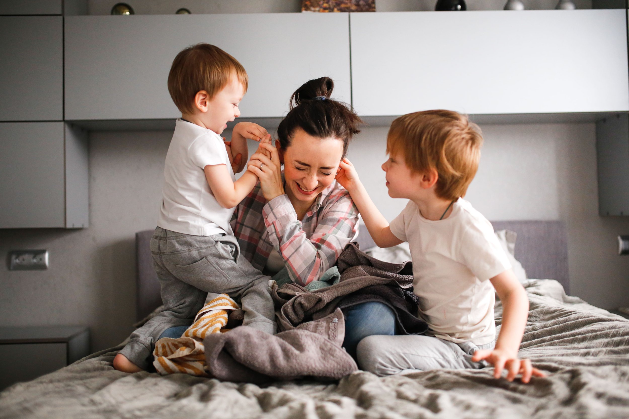 A joyful mother embracing her two children, illustrating the hope and recovery possible from postpartum anxiety and maternal mental health challenges with specialized counseling in NPR.