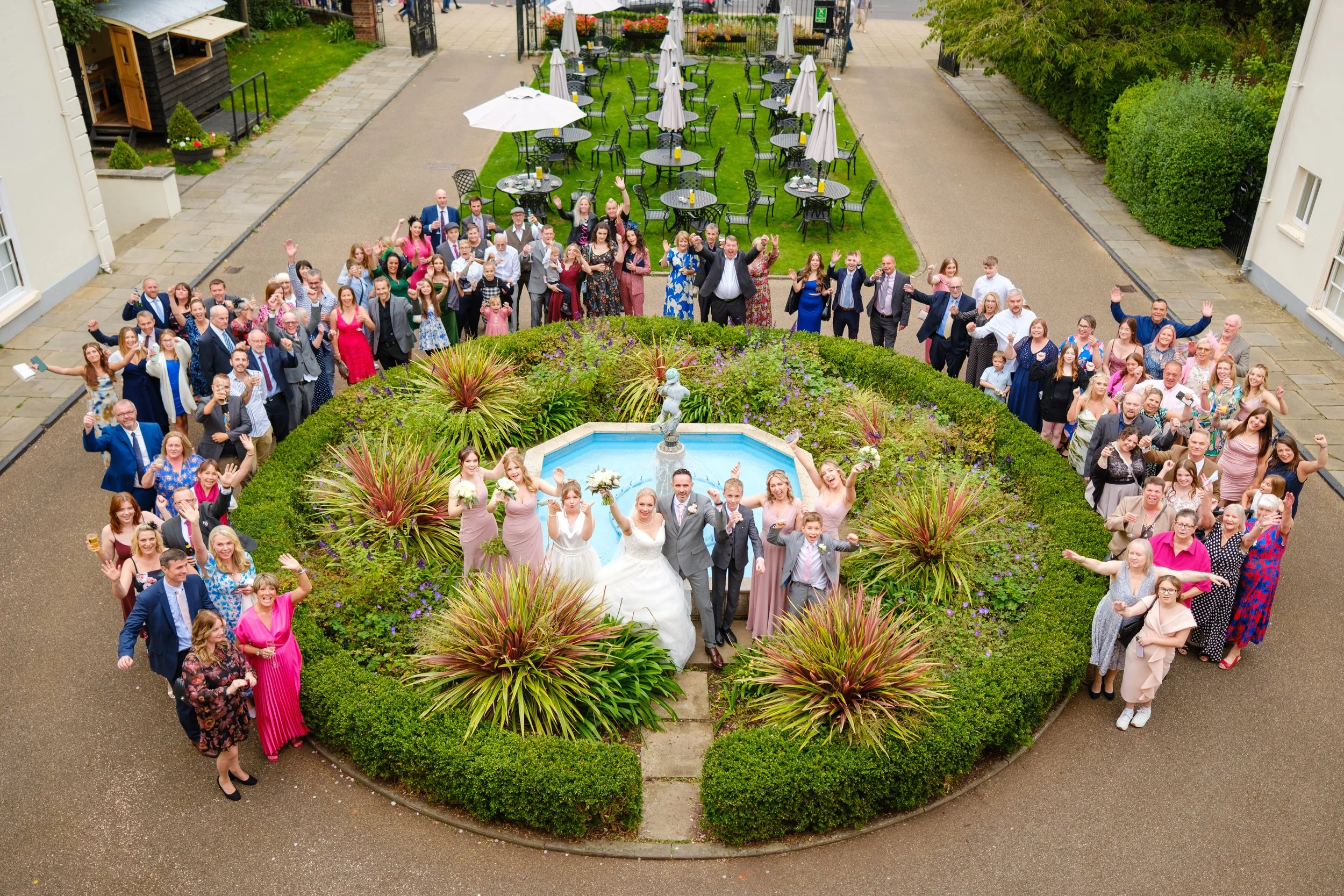 Wedding couple surrounded by their guests in the gardens at The Assembly House in Norwich