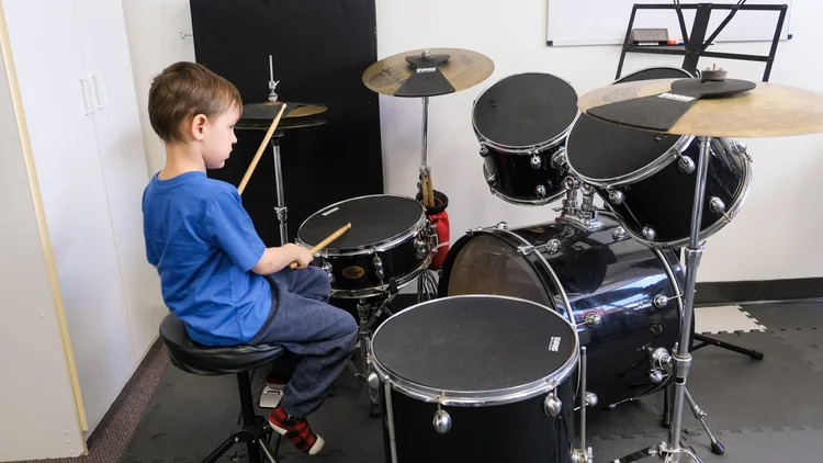 A child playing drums independently in Music Foundations