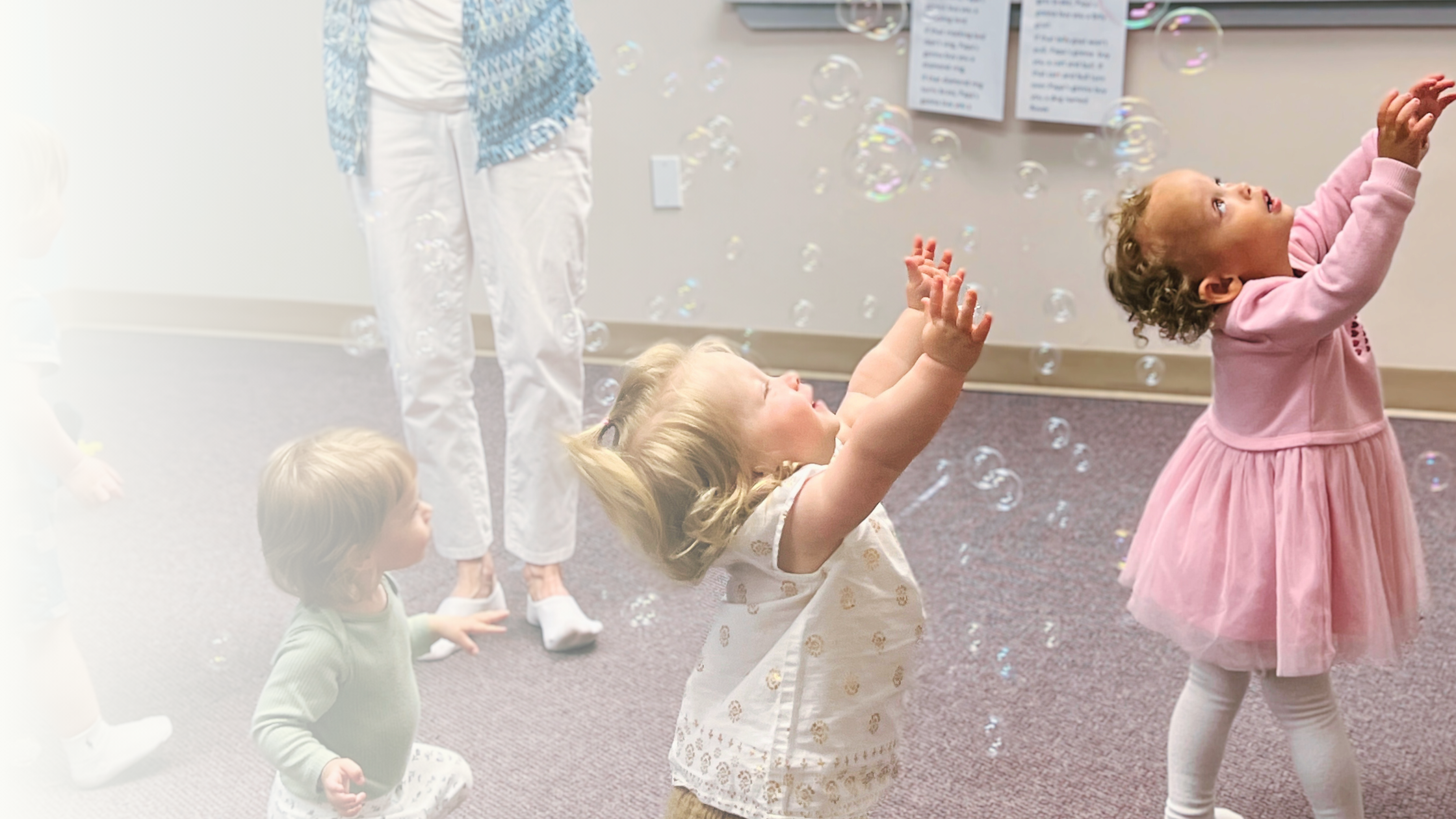Toddlers playing with bubbles in a social music group class for families.