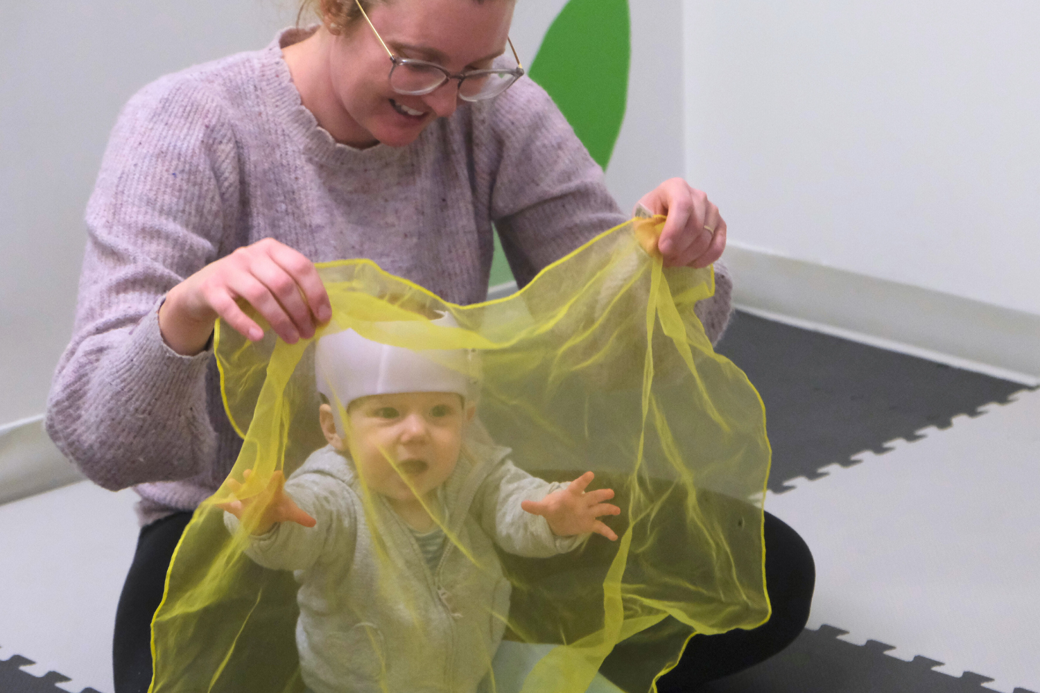 Infant learns to move and express themselves through music and play with scarves