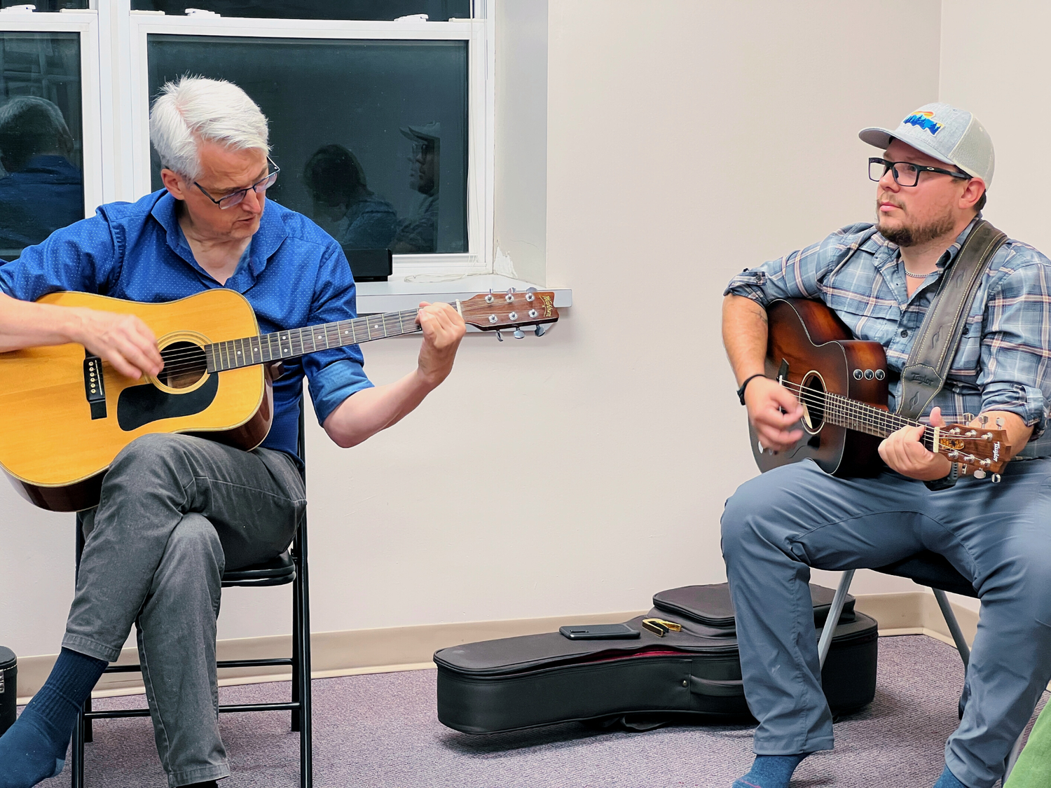 Adult students learning guitar together at Yellow Brick Music