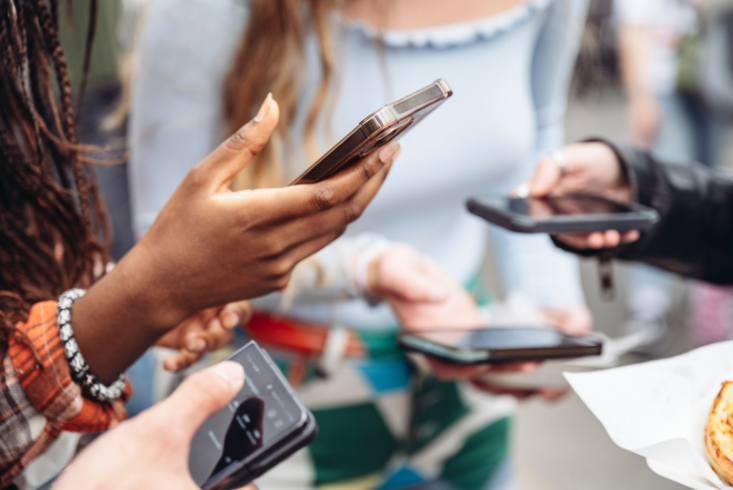 A close up of hands holding cell phones