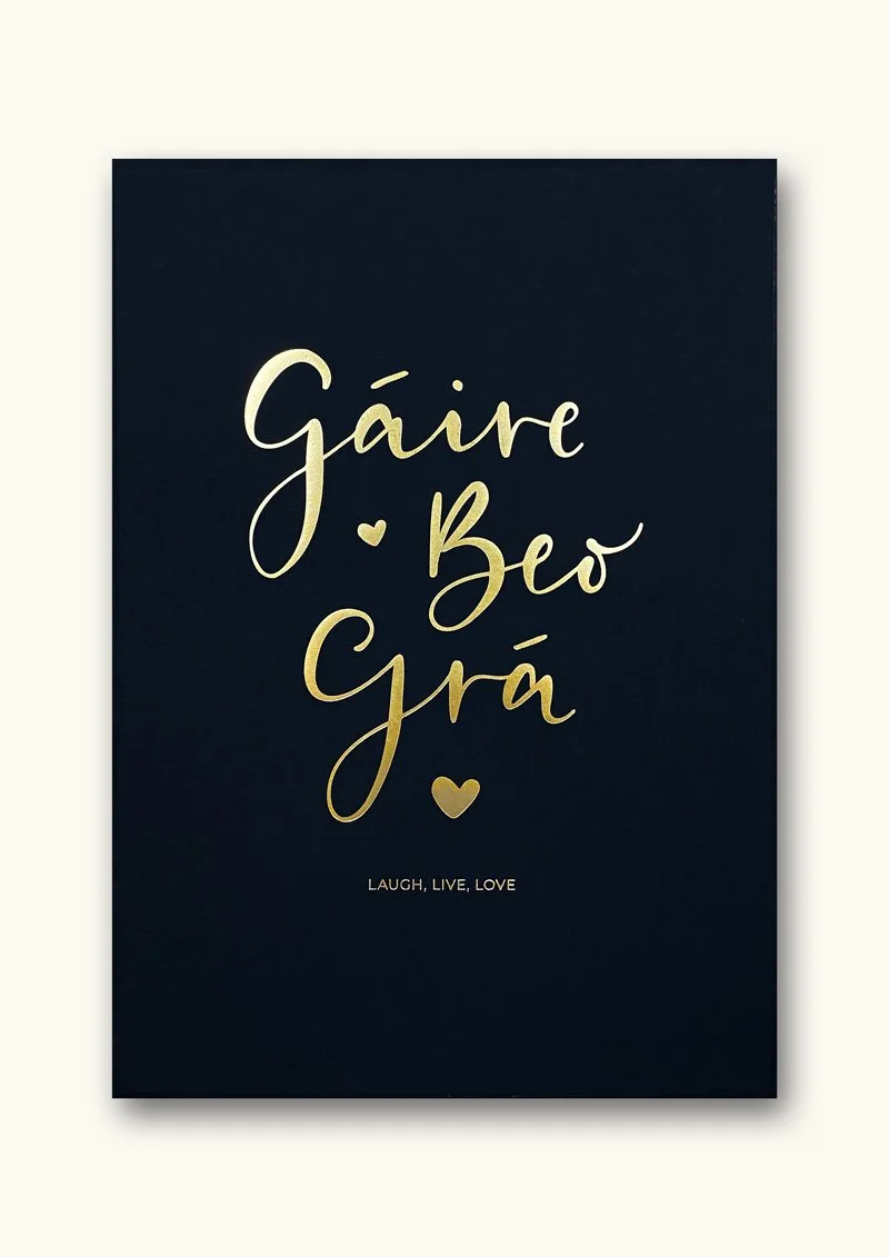 Black card with gold cursive text in another language, with small gold hearts and the words "Laugh, Live, Love" at the bottom.