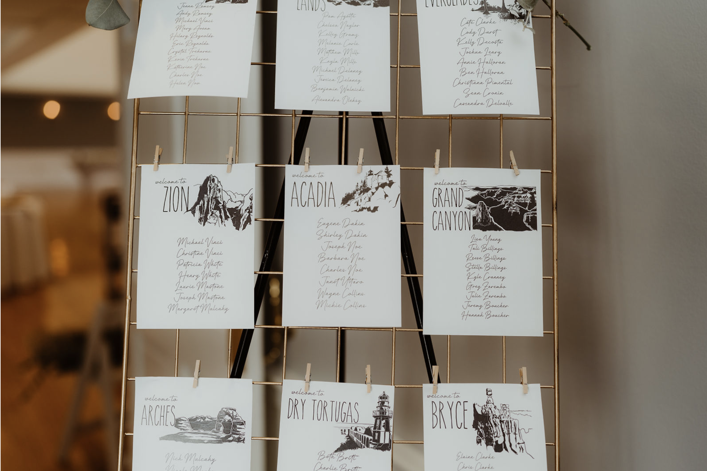 Welcome sign-in cards for various national parks and locations, including Zion, Acadia, Grand Canyon, Arches, Dry Tortugas, and Bryce, with illustrations of each site. Handwritten names of guests are listed on each card.