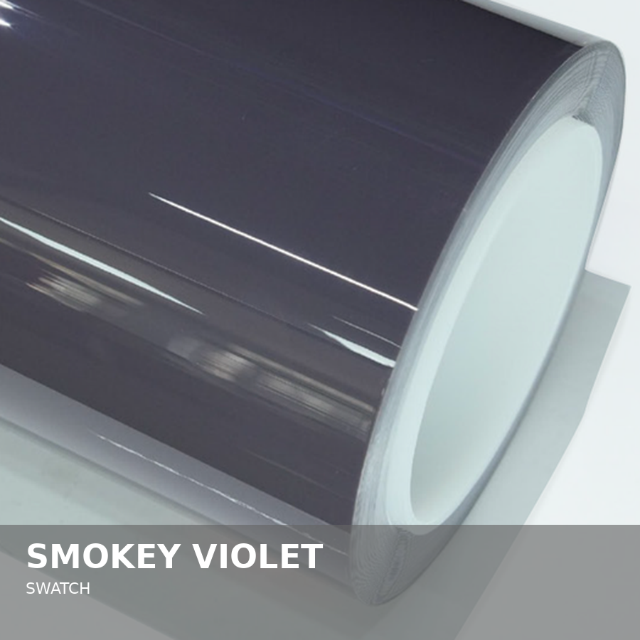 Close-up of a roll of black vinyl sticker film with a glossy finish on a white surface.