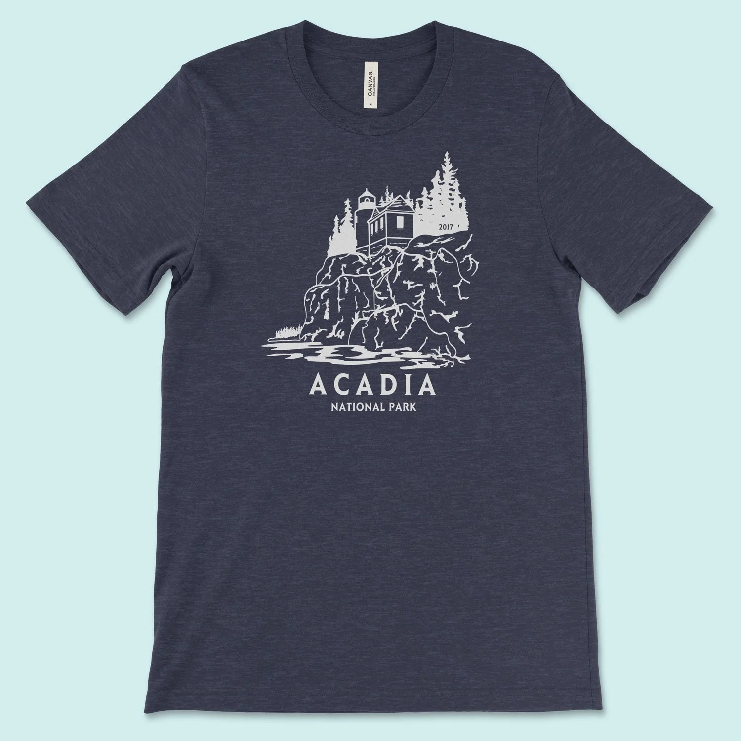 A shirt featuring Acadia National Park, with the Bar Harbor lighthouse on a cliff. It's designed in 1 color ink reminiscent of vintage postcards
