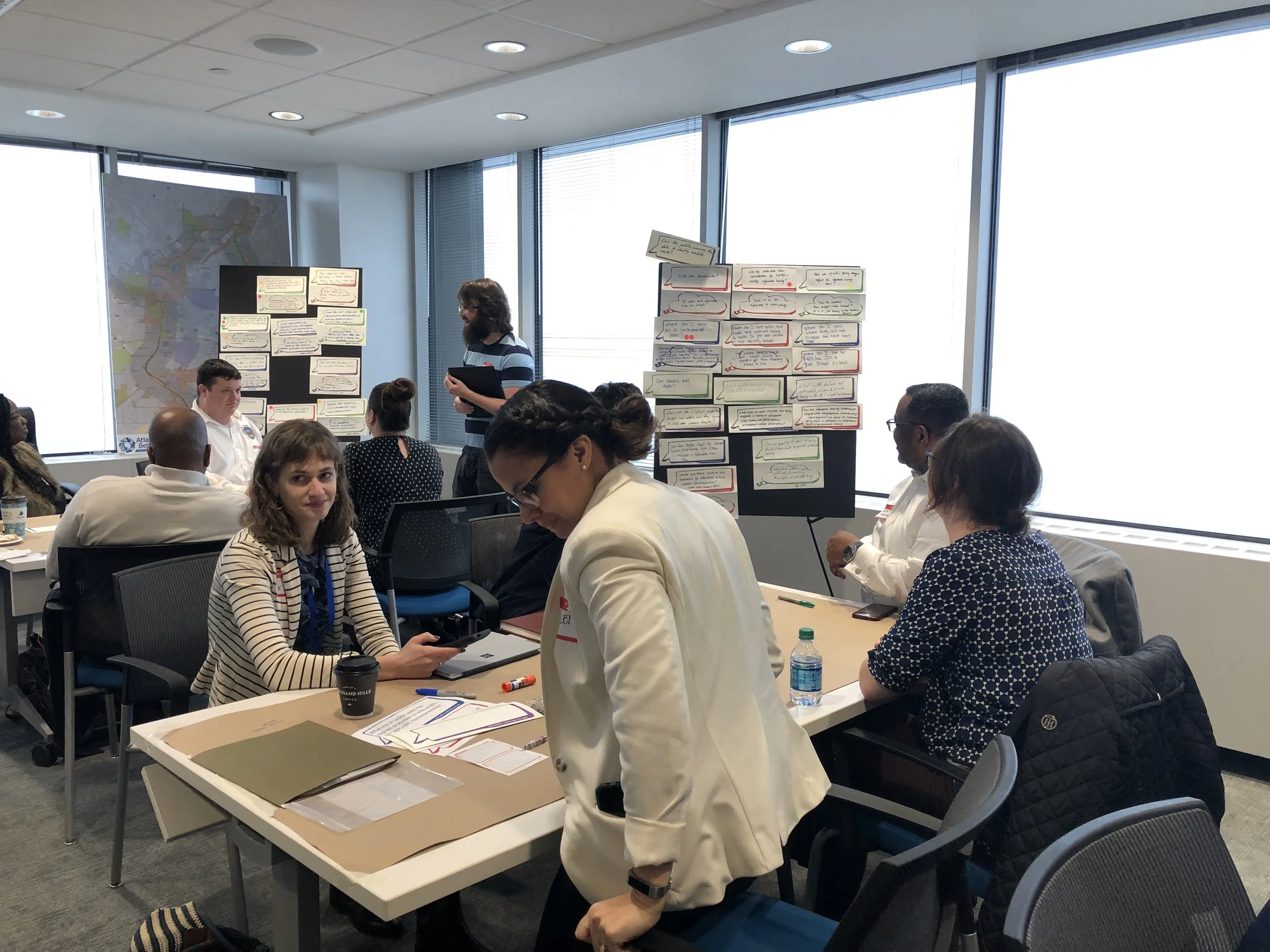 Participants are looking at the questions written and pinned up for voting.