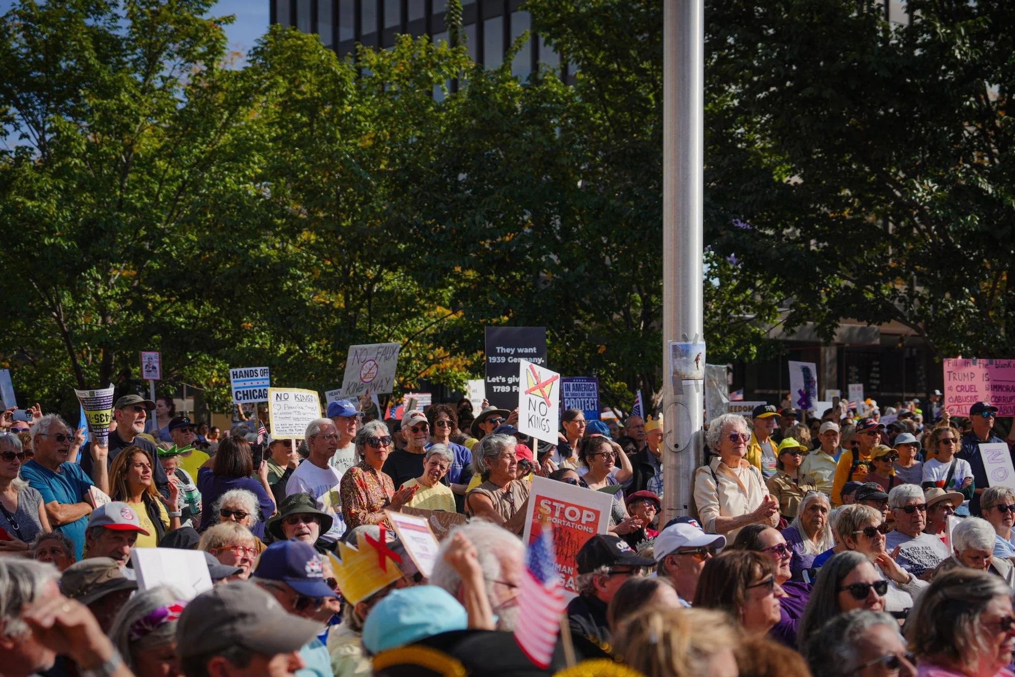 Protesters look towards the stage and listen to the speaker. 