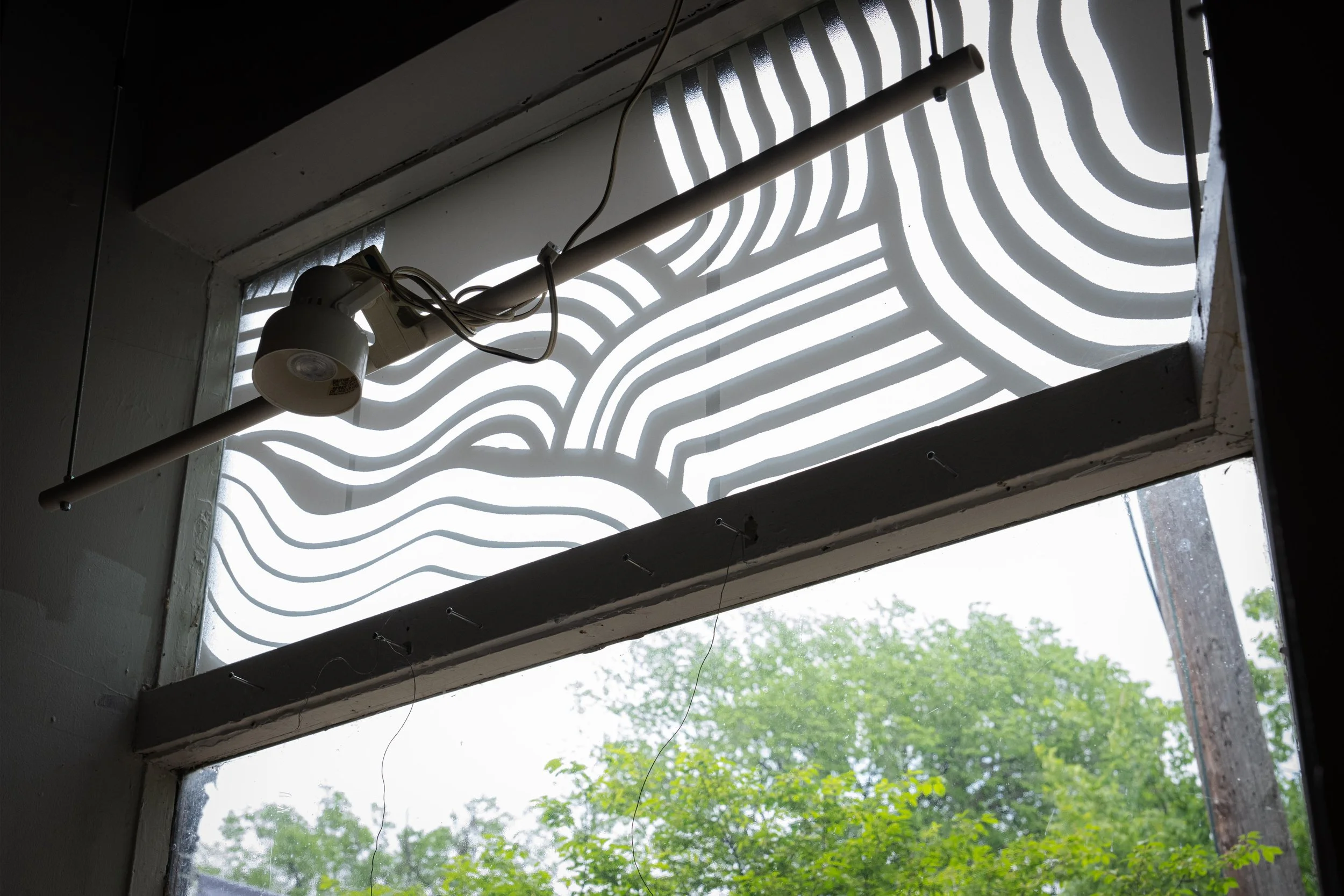 The windows of the store feature art created by artist Taro Takizawa. The piece, created using hand-cut vinyl, also serves as a bird collision prevention method.