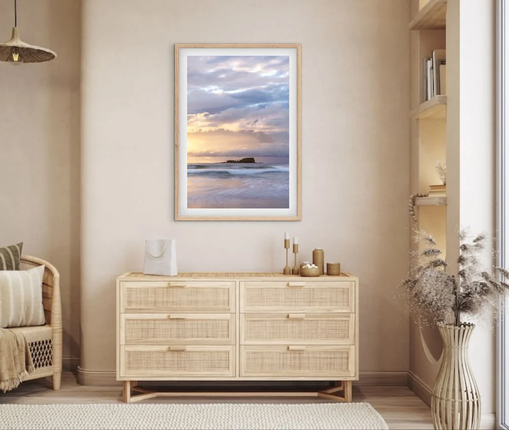Mudjimba Island sunrise coastal photography print styled above a wooden dresser in a warm neutral bedroom interior.