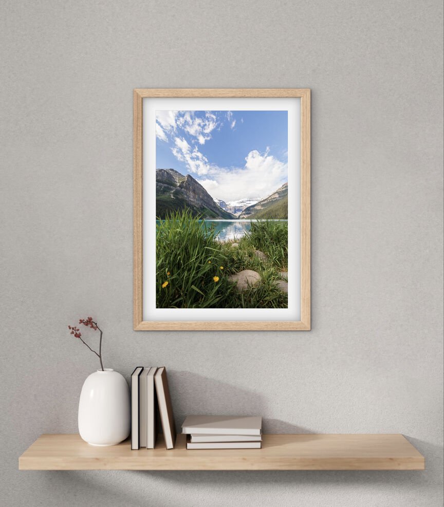 Framed Lake Louise Canadian Rockies landscape photography print displayed above a floating shelf in a minimalist interior