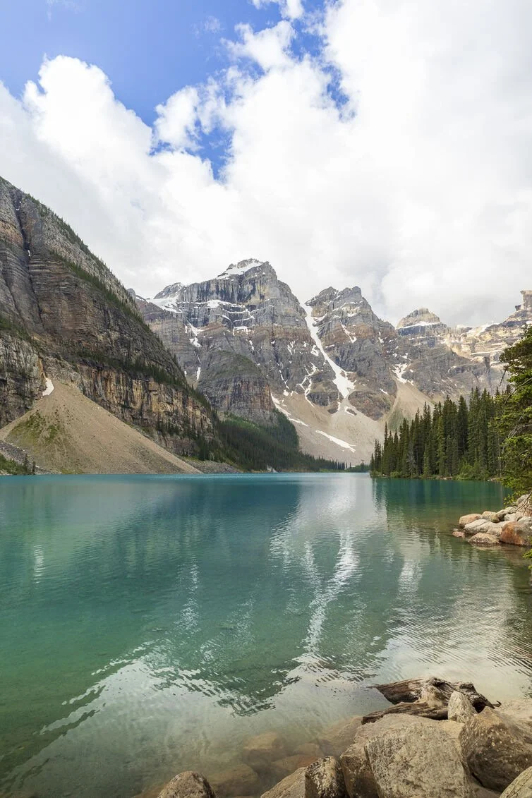 Turquoise Moraine Lake in Banff National Park Canada with snow capped peaks of the Valley of the Ten Peaks reflected in calm water
