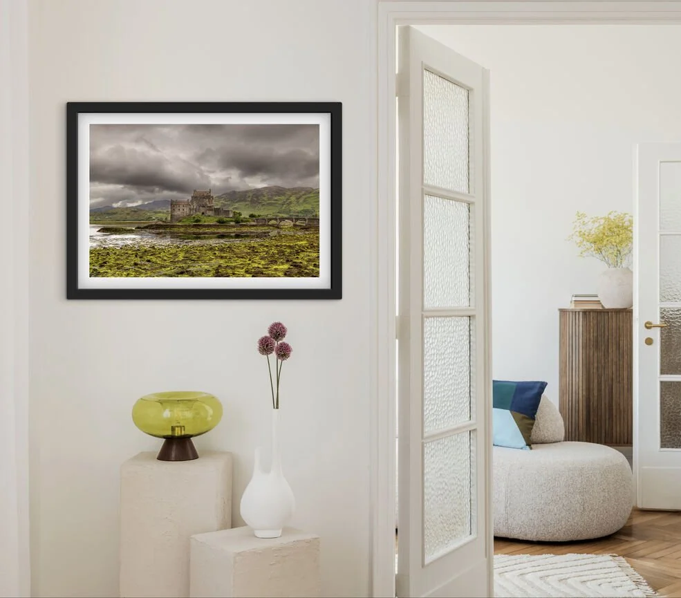 Framed Eilean Donan Castle Scotland photography print displayed above a sofa in a modern living room