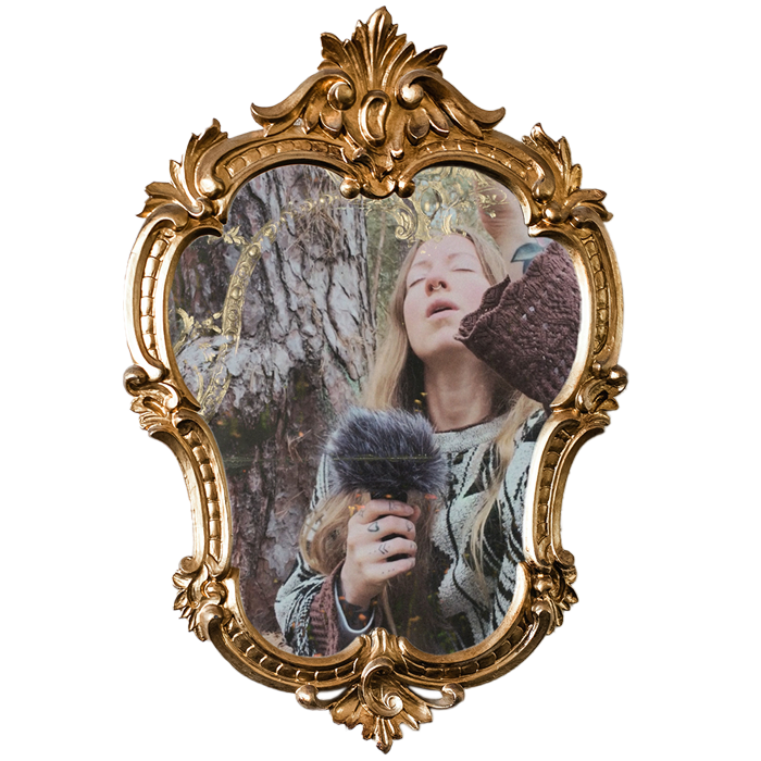 Ein goldener Barockspiegel mit einem Bild von Maria Theresia, die in der Natur vor einem Baum sitzt, ein Mikrofon in der Hand hält und singt.