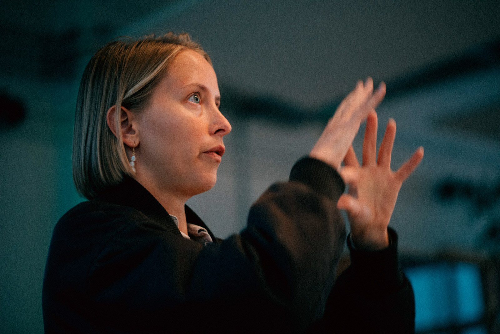 A speaker with short blonde hair gesturing while sharing her filmmaking story at a Filmmakers & Movie Nerds Speaker Event.