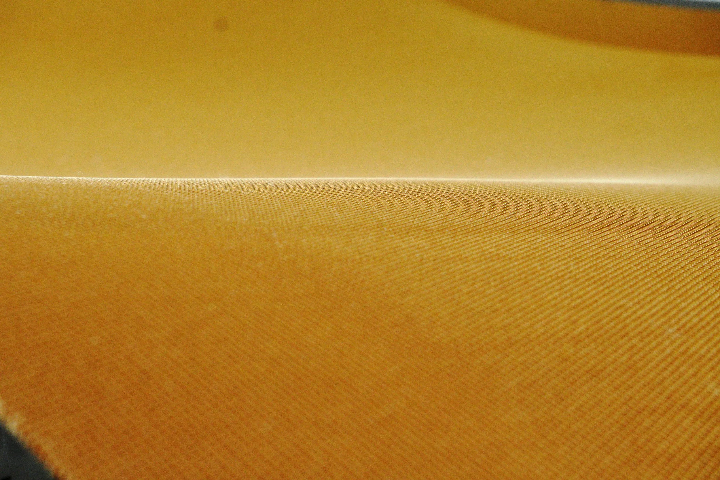 Close-up of a yellow fabric with visible texture and weave pattern.