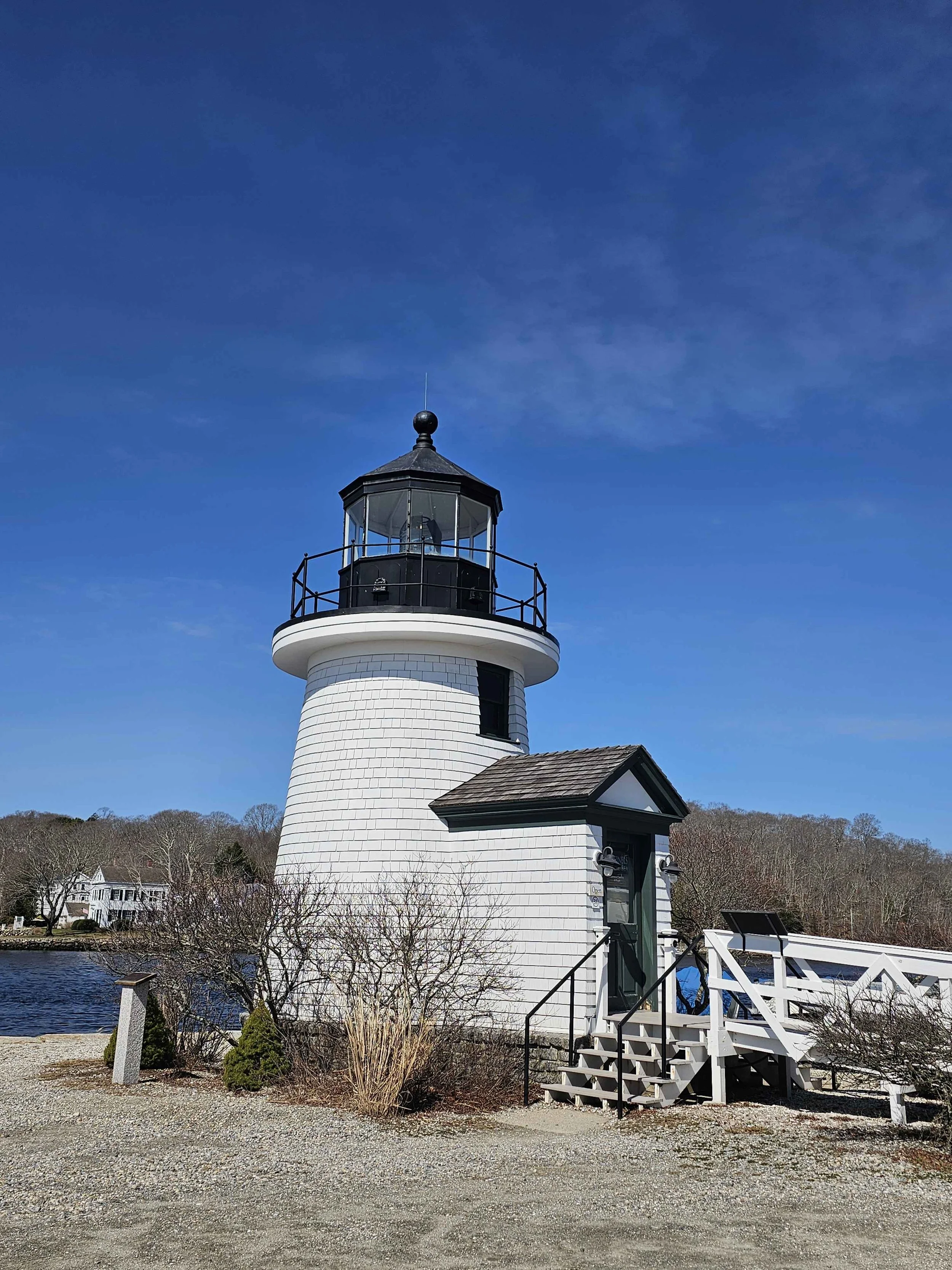 A picture of a lighthouse against the backdrop of a blue sky in Mystic Connecticut.