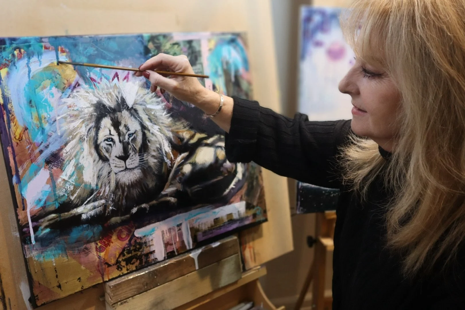 This image is of the contemporary mixed media artist Debbie painting in her studio.