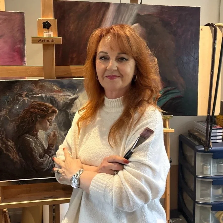 A picture of the UK artist Debbie Moylan in her Surrey Studio with her paintings in the background