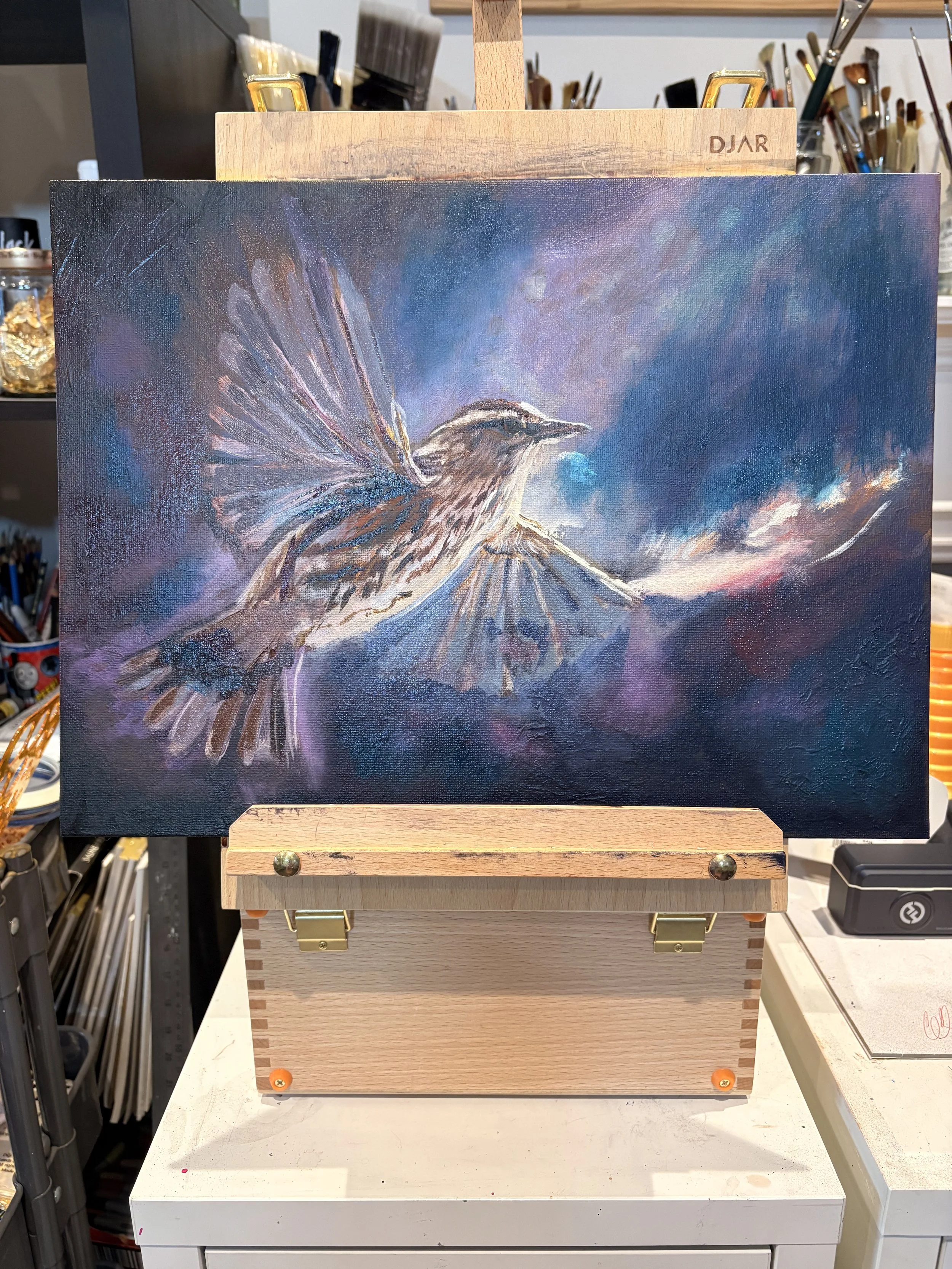 A painting of a bird flying near a volcano, with a colorful, cloudy sky in the background.