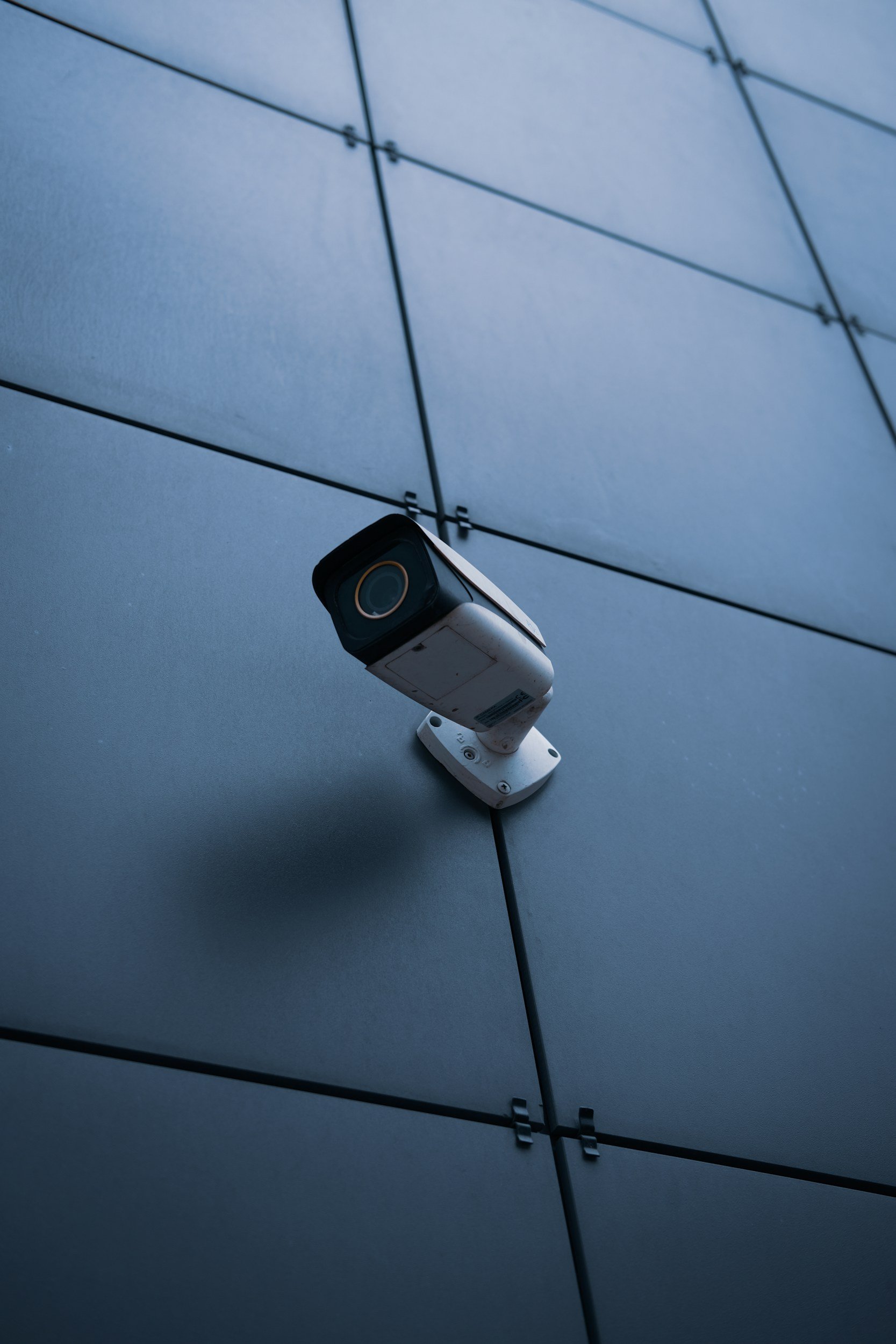 Security camera mounted on a modern building's exterior wall.