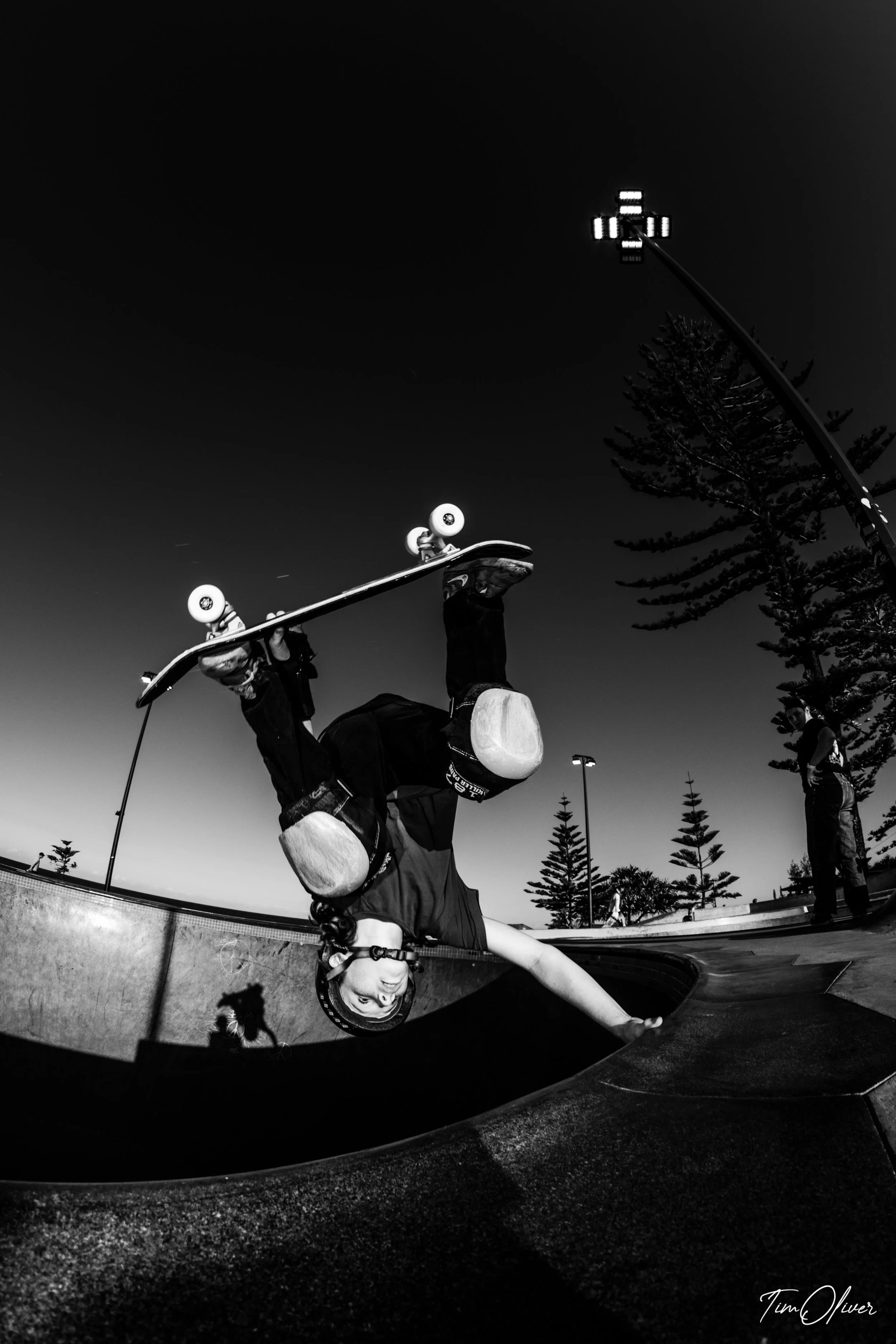 Young skateboarder at Alexandra headland skate park doing a hand plant in black and white