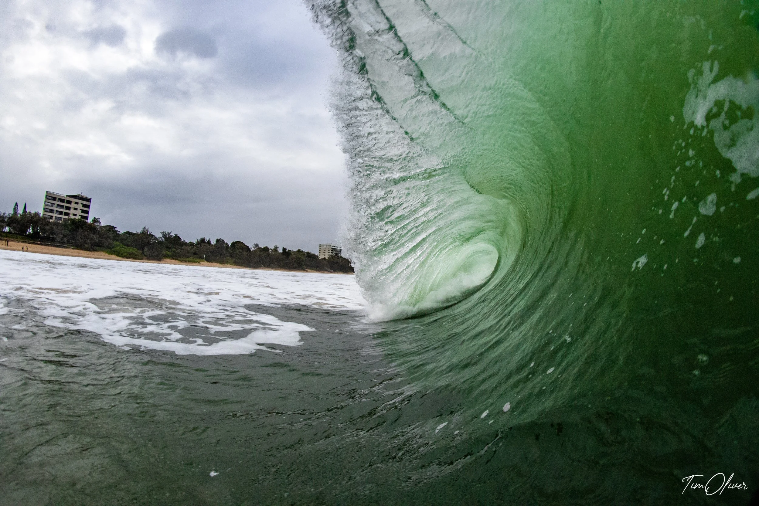 A clean wave at Mooloolaba beach with blue green, summer shore break.